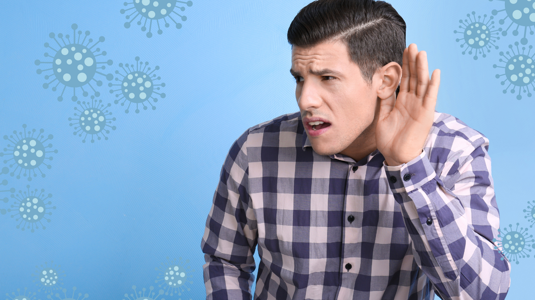 Illustration of a person with their hand on their ear, struggling to hear, with a COVID-19 virus in the background.