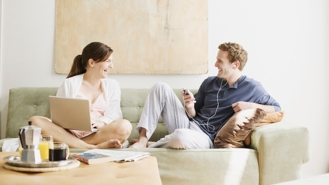A couple sitting on a couch, engaged in conversation.