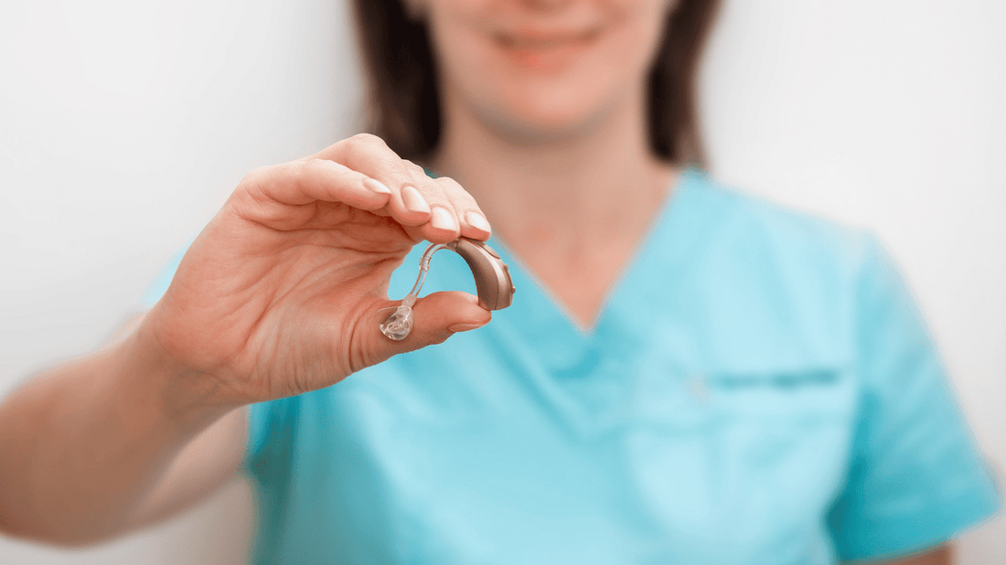 An image of a person holding affordable hearing aids in their hand, representing the affordability of hearing aids.