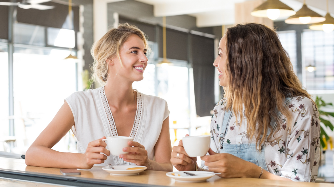 People conversing in a cozy coffee shop setting, illustrating the importance of clear hearing in social situations.