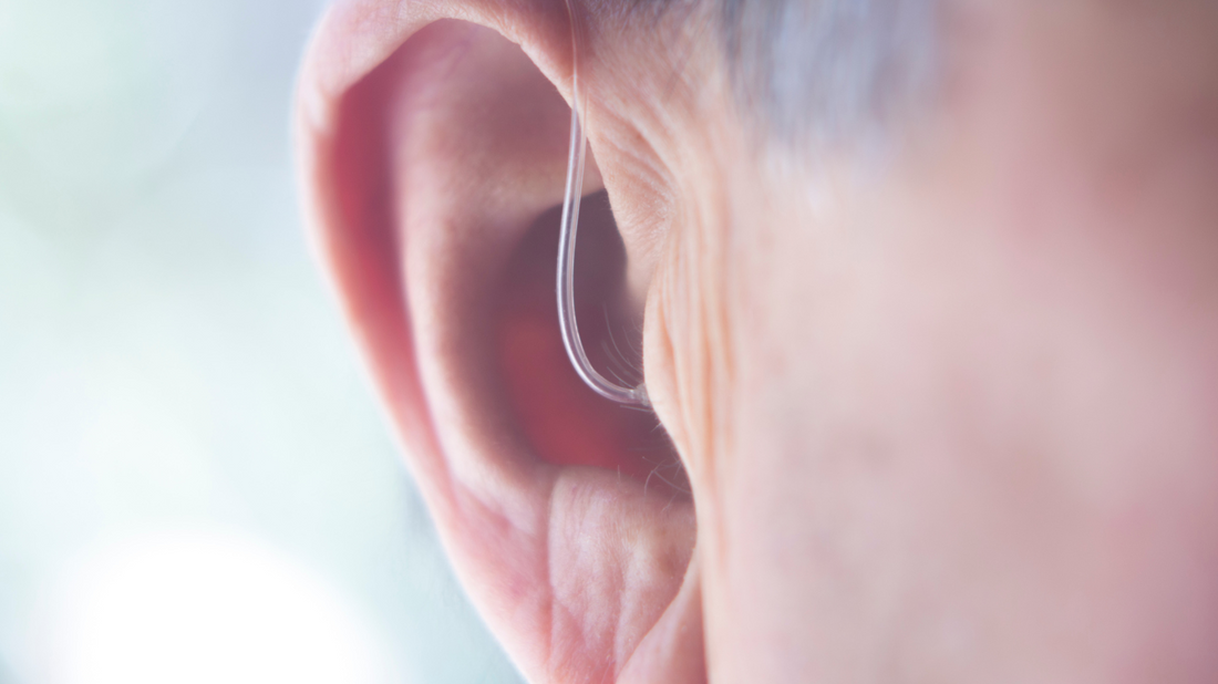 A person wearing a small, discreet hearing aid
