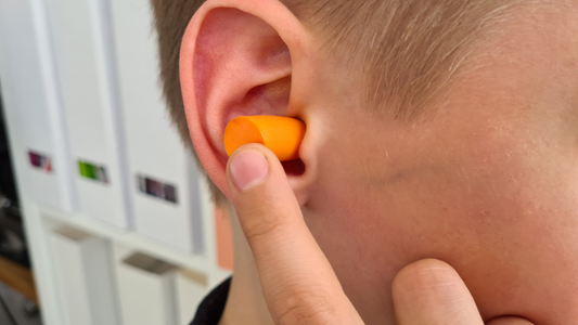 An image showing a person wearing earplugs to protect their ears from loud noise.