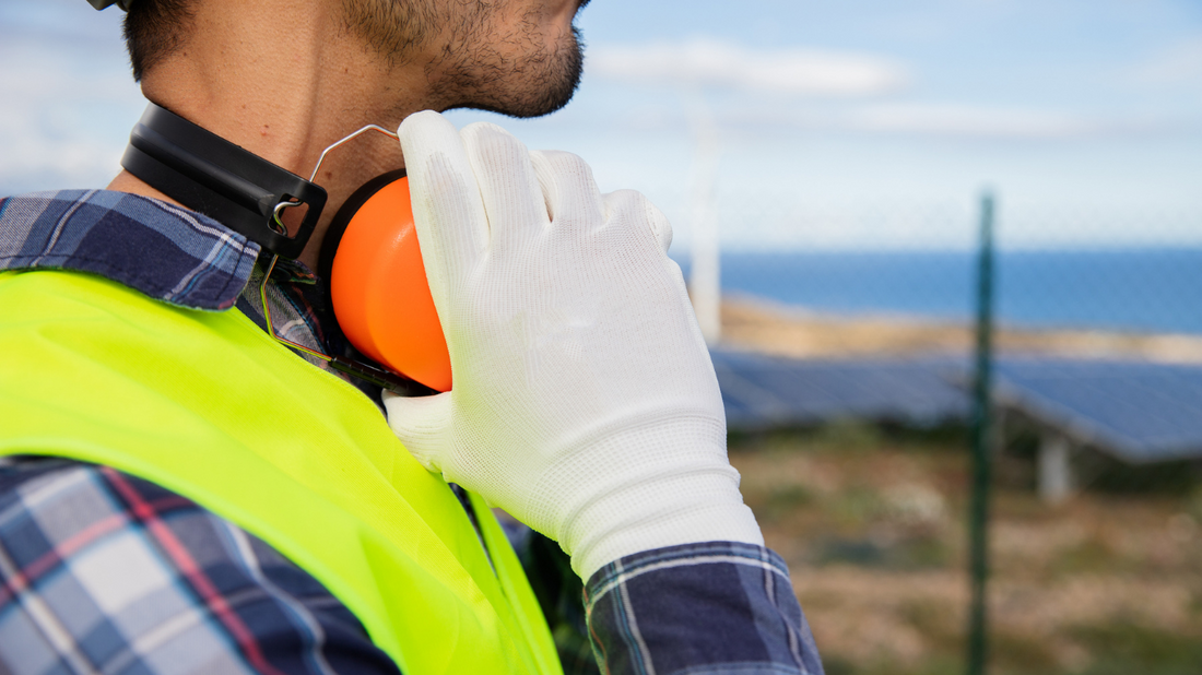 Person wearing earmuffs in a noisy industrial environment