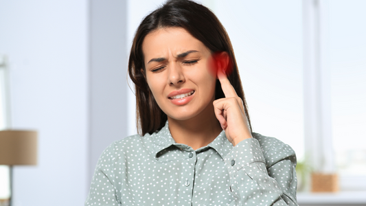 Person holding their ear in discomfort, representing the pain and discomfort of an earache.