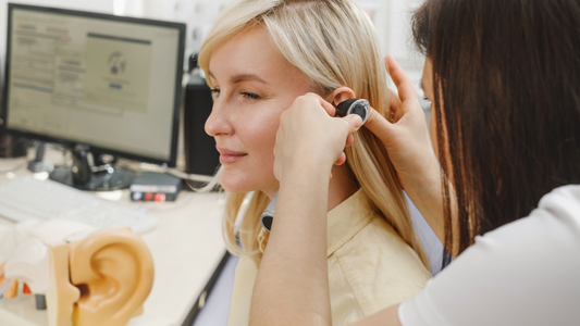 Audiologist performing hearing examination on patient.