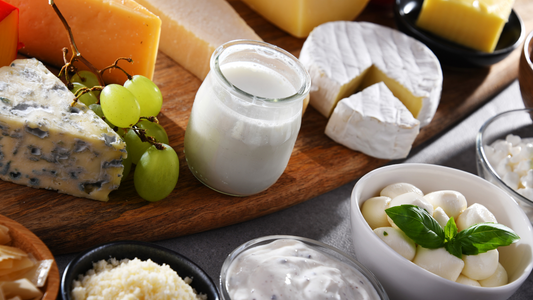 An image showing a variety of foods on a table, including bread, dairy products, and sugary treats. These are foods that may contribute to excessive ear wax production.