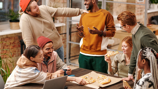 A diverse group of people laughing and conversing at a family gathering.