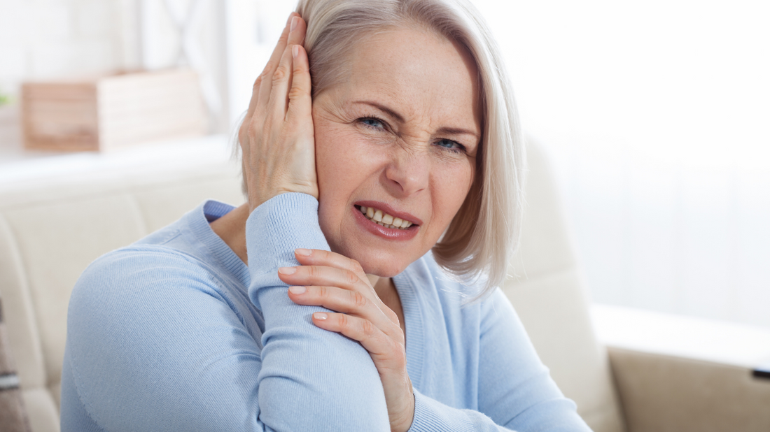 Person holding their head with a worried expression, indicating concern about tinnitus after a head injury.