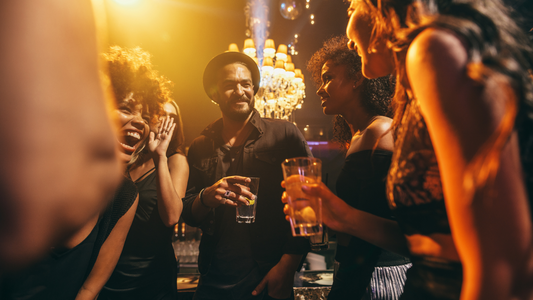 Person wearing a hearing aid engaged in conversation with friends at a party.