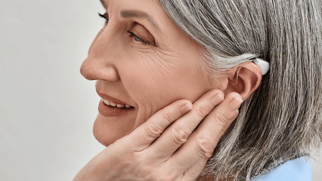 An image of a person adjusting a hearing aid, representing hearing aid tips and tricks for saving money.