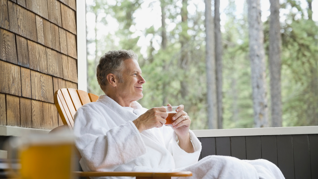 Person sitting on a porch with a cup of tea, contemplating hearing loss.