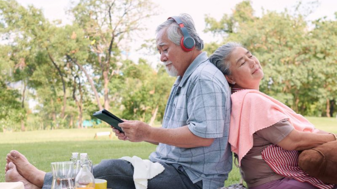 Person sitting in a serene park wearing earplugs, representing strategies for managing tinnitus.