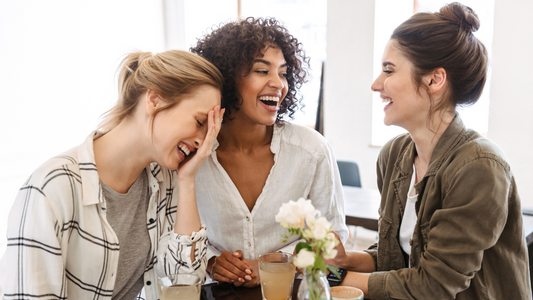 A group of diverse people engaged in conversation and laughing together.