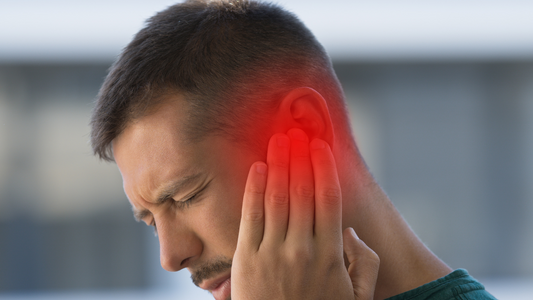 An illustration of a person touching their ear with a visual depiction of sound waves and ringing, symbolizing the experience of tinnitus.